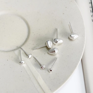 Detailed view of organic pebble-shaped 925 silver stud earrings with S925 hallmark stamp