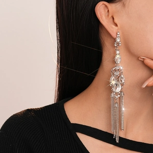 Close-up of elegant silver tassel earrings with crystal rhinestones on a model