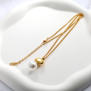 Detail view of gold oval pendant and pearl necklace with lobster clasp and chain