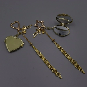 Detail of golden heart-shaped and oval folding mirrors with elegant long metal tassels