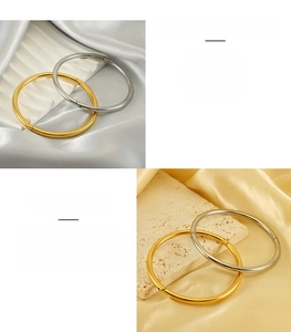 Polished stainless steel minimalist bangles in gold and silver finishes on a satin background