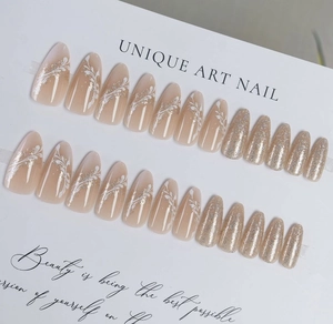 Detail of 24pcs almond press-on nails with white wave patterns and champagne gold glitter