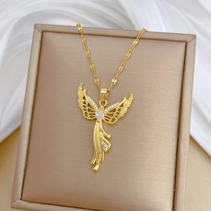 Close-up of golden eagle wing pendant with heart-shaped zircon in a beige jewelry box