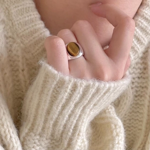 Detail view of retro silver tiger eye ring on model with knitted background