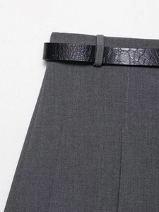Detailed view of crocodile texture black leather belt on dark grey tailored trousers