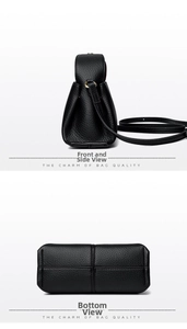 Detail view of black lychee grain leather handbag with gold rings and cross-stitch base