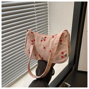 Close-up of pink corduroy shoulder bag featuring cute red cherry embroidery and zipper