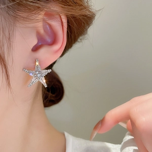 Elegant silver starfish earrings with pavé crystals on a model for a luxury style