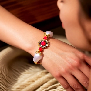 Detail eines Vintage-Blumenarmbands mit Perlen und rotem Edelstein am Handgelenk