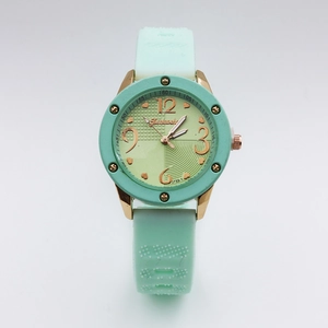 Detail of mint green quartz watch with gold case and heart pattern gradient dial