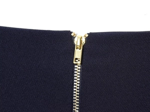 Détail du zip en métal doré sur le pantalon bleu foncé à taille haute élégant