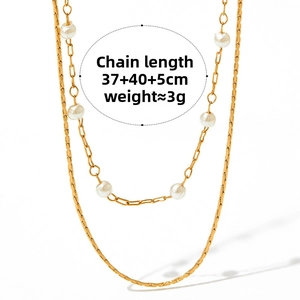 Detailed macro of a double-layered gold stainless steel necklace with delicate pearls