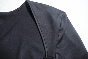 Gros plan sur le tissu en maille noire montrant les coutures de l'épaule et la texture