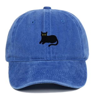 Close-up of black cat embroidery on a vintage blue washed cotton baseball cap texture