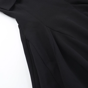 Close-up of the black woven fabric texture and premium seam stitching on the dress