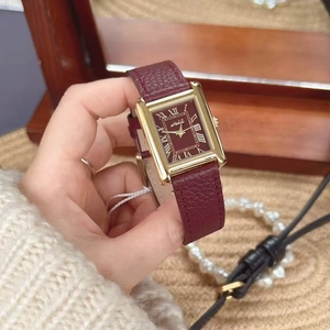 Detail of red leather strap and gold square dial on a luxury women vintage watch