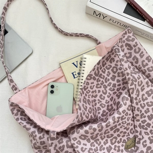 Detail view of pink leopard print tote bag with spacious interior and gold logo