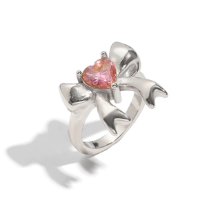 Silver bow ring with pink heart gemstone and polished finish on white background