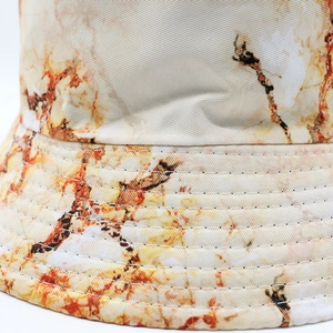 Detailed macro view of marble print fabric and reinforced stitching on reversible bucket hat