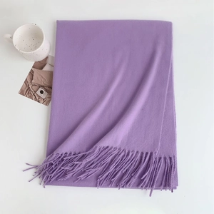 Detail of soft purple cashmere-feel scarf with elegant fringe trim on white background