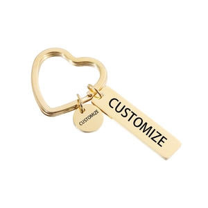 Detailed view of golden heart-shaped keychain with customizable engraved metal tags