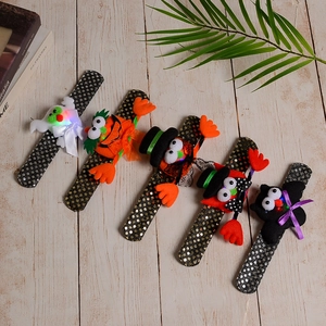 Detail view of five sequined Halloween LED snap bracelets on a rustic wooden background
