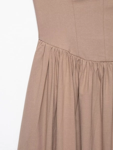Detailed view of the gathered waist and natural linen texture on a tan midi dress