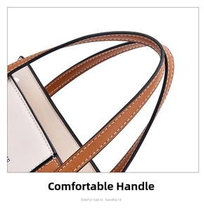 Detail of comfortable leather handles with contrast stitching on a two-tone handbag