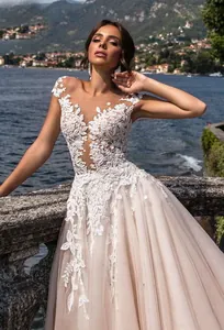 Détail de la broderie en dentelle florale blanche et du corsage transparent de la mariée