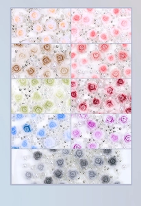 Macro view of assorted resin roses, mixed pearls and silver beads for DIY nail art design