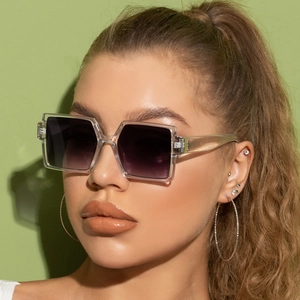 Close-up of oversized square sunglasses with transparent frames and purple gradient lenses