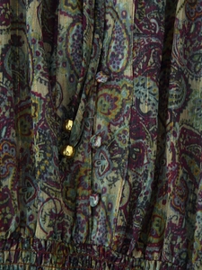 Detail of paisley print chiffon with gold metallic threads and beaded drawstring accent