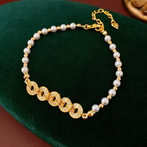 Macro detail of pearl bracelet with zircon rings and a small heart charm on velvet