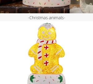 Close-up of a glowing gingerbread man music box with internal glitter and festive scarf