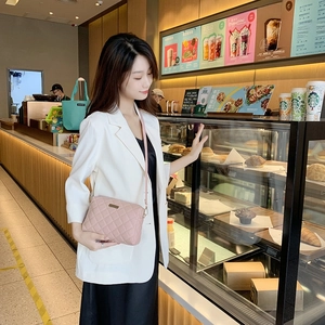 Quilted light pink crossbody bag for women with elegant chain strap and metal nameplate