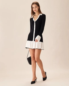 Detailed view of black knit dress featuring a polo collar and white ruffled hem accents