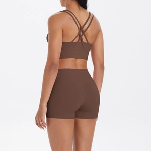 Détail des bretelles croisées sur le soutien-gorge de sport marron et short de yoga
