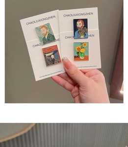 Detailed close-up of Van Gogh sunflower and portrait enamel pins on card packaging