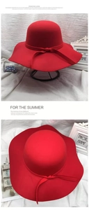 Detail of elegant red wide-brim wool cloche hat featuring a stylish ribbon bow ornament