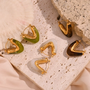Detailed set of V-shaped gold hoop earrings with green, white, and brown resin inserts