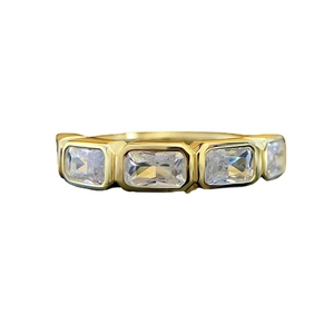Minimalist gold-plated ring with four rectangular clear zircons on a white background