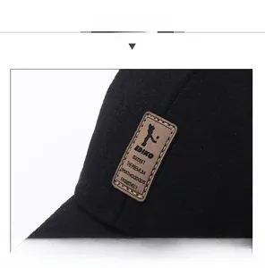 Detail view of the black wool baseball cap featuring a leather logo patch and fine stitching
