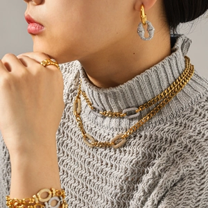 Detailansicht eines Modells mit hochwertigem, mehrlagigem Schmuck aus Edelstahl.