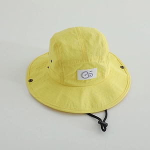Détail d'un chapeau bob enfant jaune avec broderie 'Go', aérations et mentonnière
