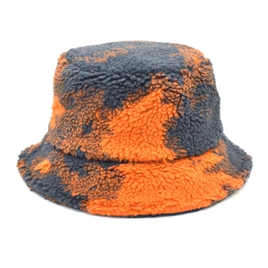 Détail d'un bob en peluche avec motif tie-dye orange et gris et tissu texturé doux