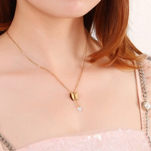 Goldene Edelstahlkette mit Schmetterlingsanhänger und Zirkonia-Stein an einem Model
