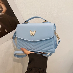 Light blue V-quilted small square crossbody bag with a golden butterfly clasp detail