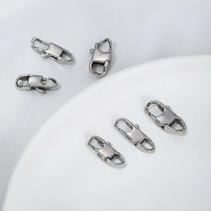 Polished silver stainless steel lobster clasps for jewelry making displayed on a white plate