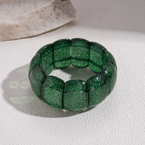 Detailed view of the wide stretch bracelet featuring glittering emerald green resin tiles