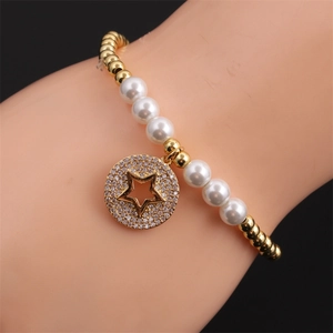 Elegant gold bead and pearl bracelet with a sparkling zircon star pendant on wrist